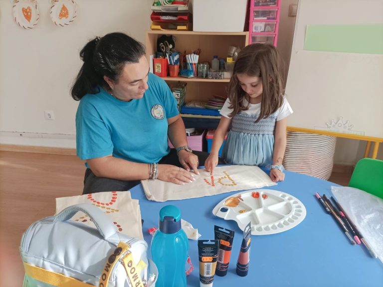 Educadora e criança em atividade pedagógica de pintura
