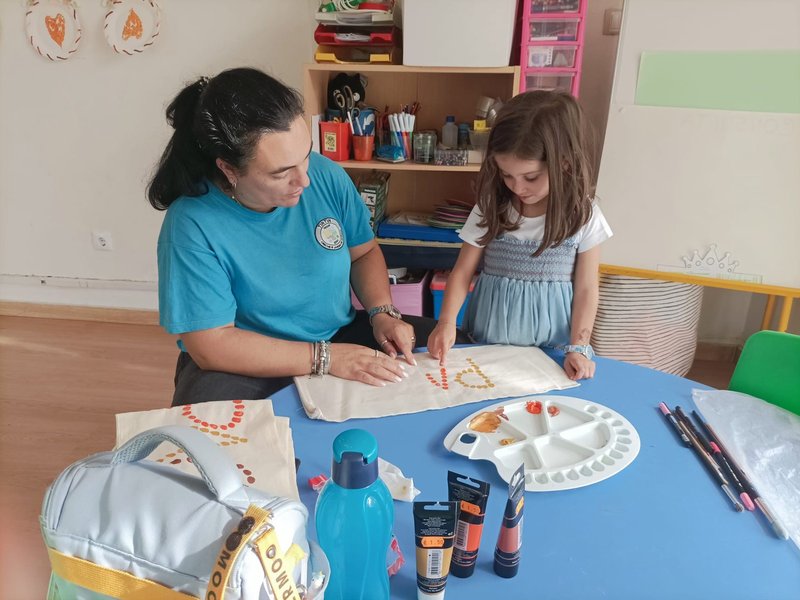 Educadora e criança em atividade pedagógica